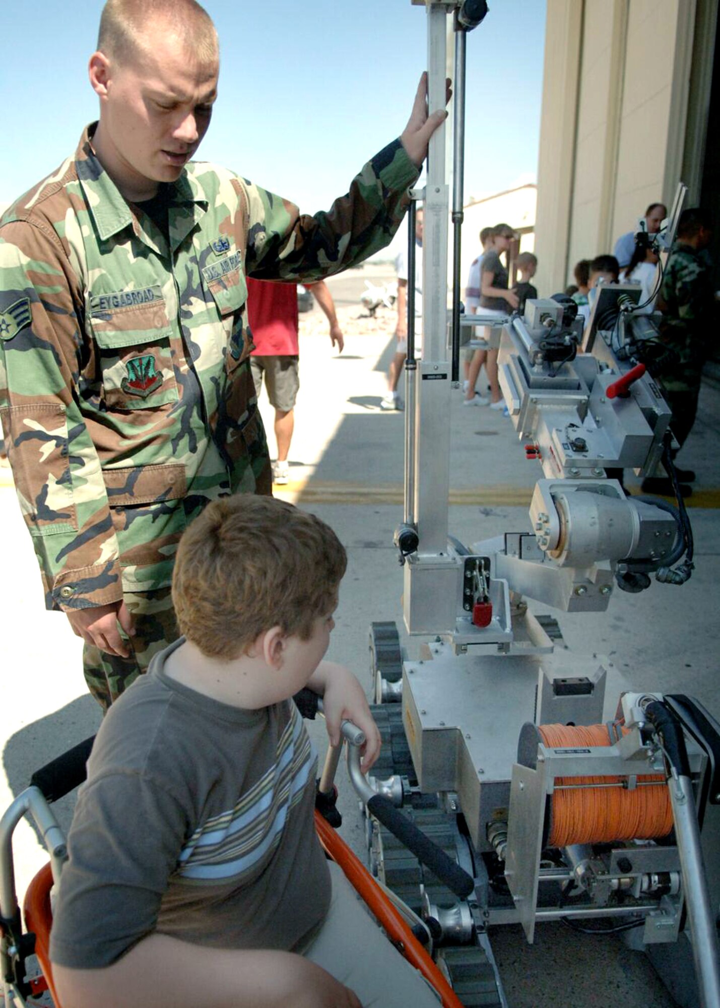 Senior Airman Travis Eygabroad shows Lawton Lucas the explosive ordnance disposal robot during a tour of Davis-Monthan Air Force Base, Ariz., on July 17. The Make-A-Wish Foundation teamed with Davis-Monthan to offer a tour of the base for Lawton and other Make-A-Wish children as well as their families. The tour consisted of demonstrations by an EOD robot, base fire department and a weapons loading crew for an A-10 Thunderbolt II. Airman Eygabroad is an EOD technician from the 355th Civil Engineering Squadron. (U.S. Air Force photo/Senior Airman Christina D. Ponte)
