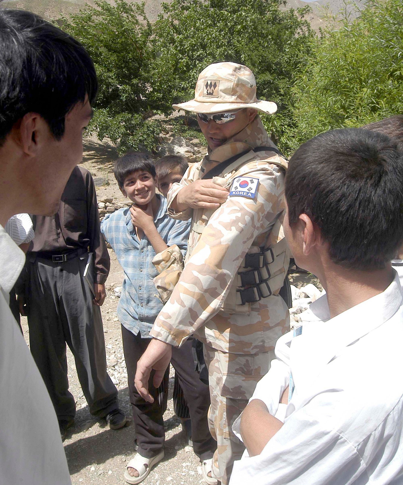 Korean Army Capt. Byung Wook Moon tells Afghan children about his home country during the opening of a Bridge in Parwan Province, Afghanistan.  Captain Moon is a member of the Bagram Provincial Reconstruction Team, which is led by the U.S. Air Force and is tasked with performing security, interfacing with the provincial government and leading reconstruction efforts.  (US Air Force photo/Maj. David Kurle)