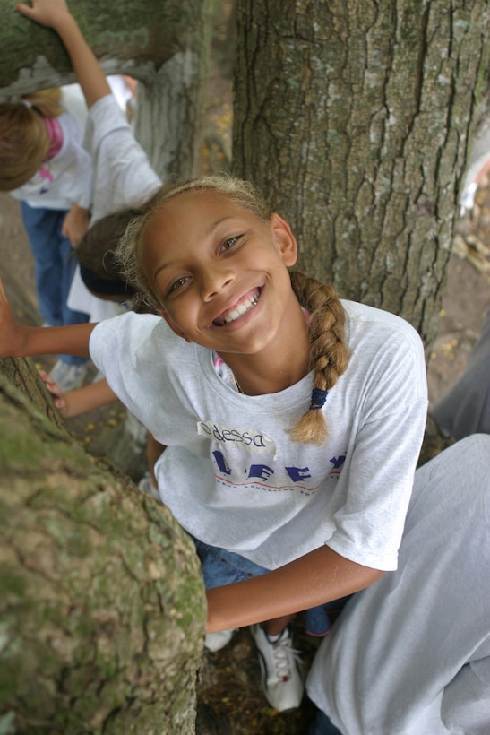 Odessa J. Chandler, 10-year-old DEFY mentee, strikes a pose while climbing through a tree during a leadership building activity, July 25, at Kualoa Ranch