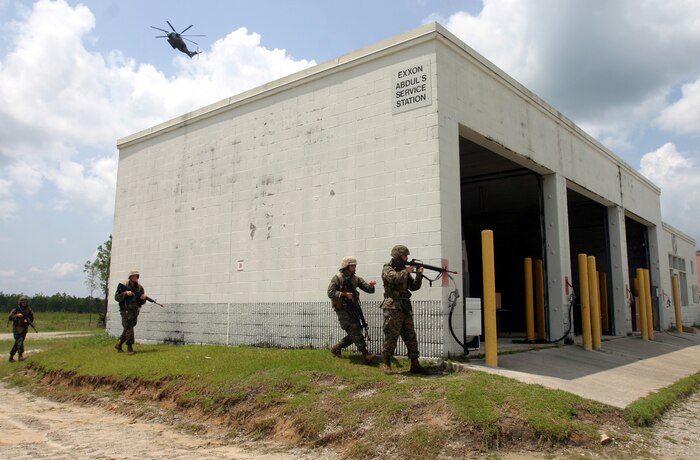 MARINE CORPS BASE CAMP LEJEUNE, N.C. (July 26, 2006) ? A CH-53 helicopter flies overhead as Marines cross a street that could pose potential danger during training here July 26. Marines with Combat Logistics Regiment 27, 2nd Marine Logistics Group learned how to patrol, enter buildings, clear rooms and maintain themselves in an urban environment during a Basic Urban Combat Training course here, July 24 through 28.