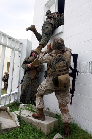MARINE CORPS BASE CAMP LEJEUNE, N.C. (July 26, 2006) ? Marines lift another into an open window after receiving fire from an insurgent inside the building during training here July 26. Marines with Combat Logistics Regiment 27, 2nd Marine Logistics Group learned how to patrol, enter buildings, clear rooms and maintain themselves in an urban environment during a Basic Urban Combat Training course here, July 24 through 28.