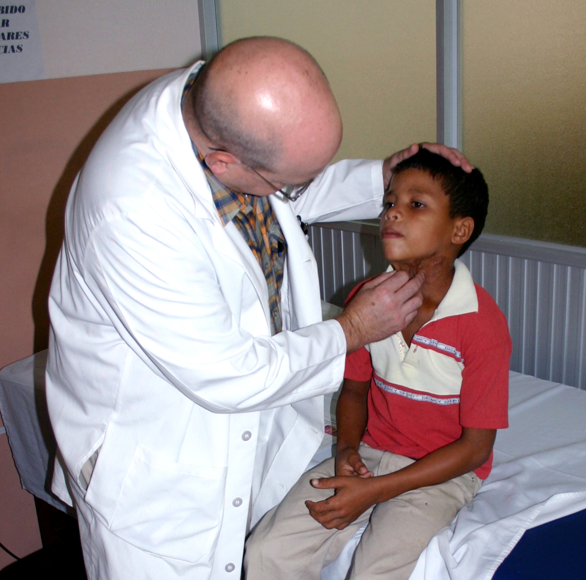 Col. (Dr.) Charles Hardin checks the burn injuries of an Ecuadorian boy during a screening with the first Medical Readiness Training Exercise team in Esmereldas, Ecuador. Colonel Hardin is a surgeon at Wilford Hall Medical Center at Lackland Air Force Base, Texas. (U.S. Air Force photo/2nd Lt. David Herndon) 
