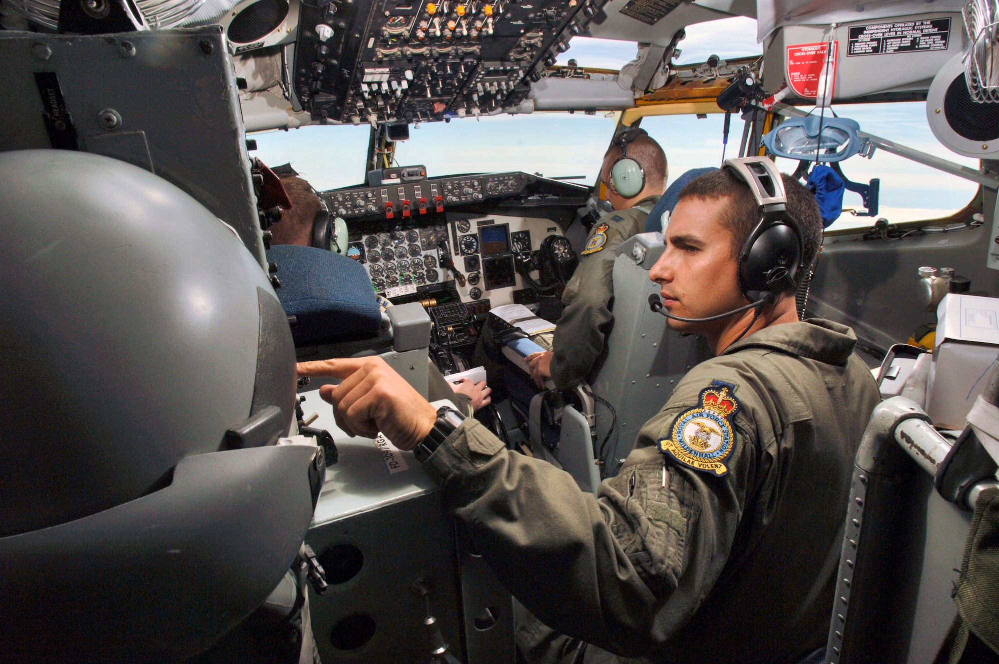 Capt. Joseph Petrosky (right) adjusts his intercom settings aboard a KC-135 Stratotanker on July 25. Captain Petrosky, an instructor pilot, mentored Capts. Rob Kline (left) and Sam Ensminger on the duties and responsibilities of being aircraft commanders. The 351st Air Refueling Squadron aircrew launched from Royal Air Force Mildenhall, England, and refueled six Belgian F-16 Fighting Falcons over the North Sea participating in exercise Wycombe Warrior. (U.S. Air Force photo/Master Sgt. Lance Cheung) 
