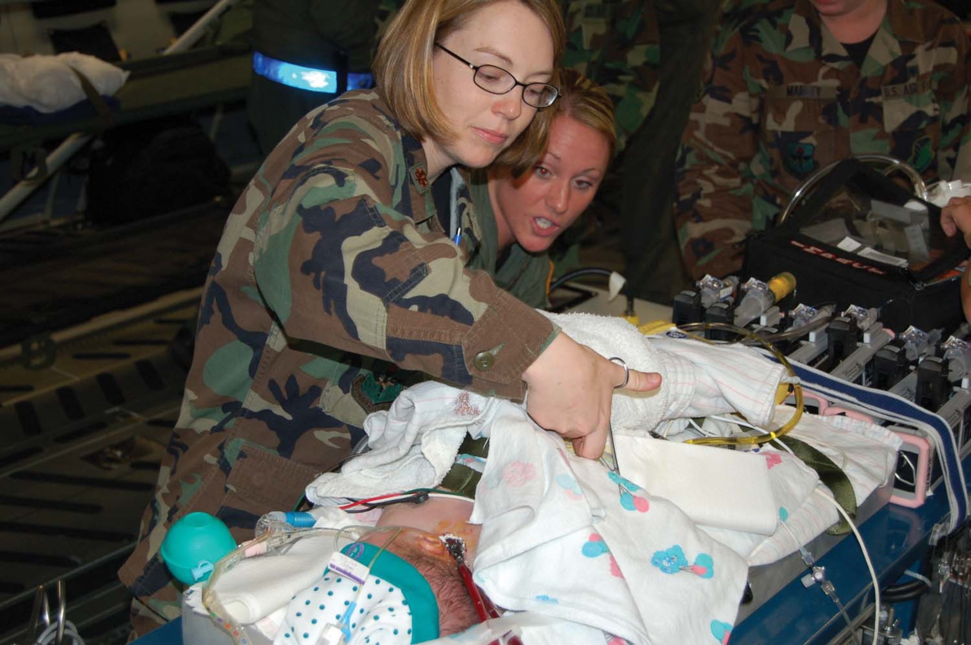 Reserve and active-duty air and medical crews joined to save the life of a 3-day-old military dependant. The boy was flow from Puerto Rico to Wilford Hall Medical Center July 20. The aeromedical evacuation crew was from the 433rd Aeromedical Evacuation Squadron, the Reserve aircrew from the 446th Airlift Wing at McChord AFB, and an Extracorporeal Membrane Oxygen Machine team was an active-duty medical crew from the 59th Medical Wing at Wilford Hall Medical Center. The units brought the boy to WHMC for life saving treatment. Pictured are Maj. (Dr.) Jeanette Gonzalez, left, a 859th Medical Operations Squadron pediatrician and Senior Airman Jayme McUlob, a 433rd AES medical technichian, right. (U.S. Air Force photo/Capt. Bruce Hill, Jr.)
