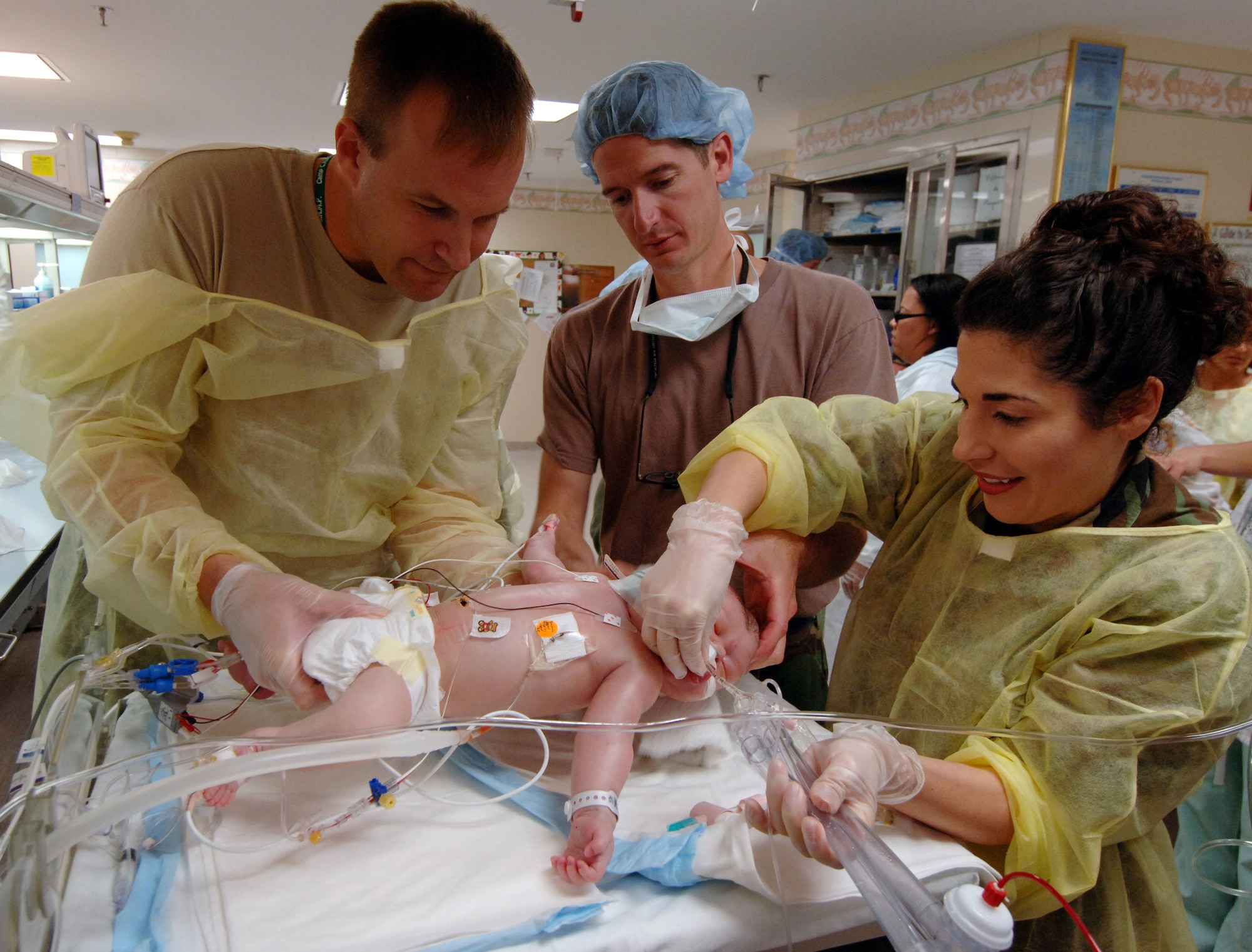 (From left) Army Lt. Col. Mark Croley and Lt. Col. Christopher Coppola and Maj. Melissa Tyree prepare 3-day-old Stuart Parker for surgery to place him on a transportable Extracorporeal Membrane Oxygenation unit on July 21 in San Juan, Puerto Rico. An ECMO team comprised Air Force and Army medical specialists from the Wilford Hall Medical Center at Lackland Air Force Base, Texas, flew to Puerto Rico to transport Stuart to San Antonio for more advanced care. Colonel Croley and Major Tyree are neonatal doctors and Colonel Coppola is a pediatric surgeon at the Wilford Hall Medical Center. (U.S. Air Force photo/Master Sgt. Scott Reed) 