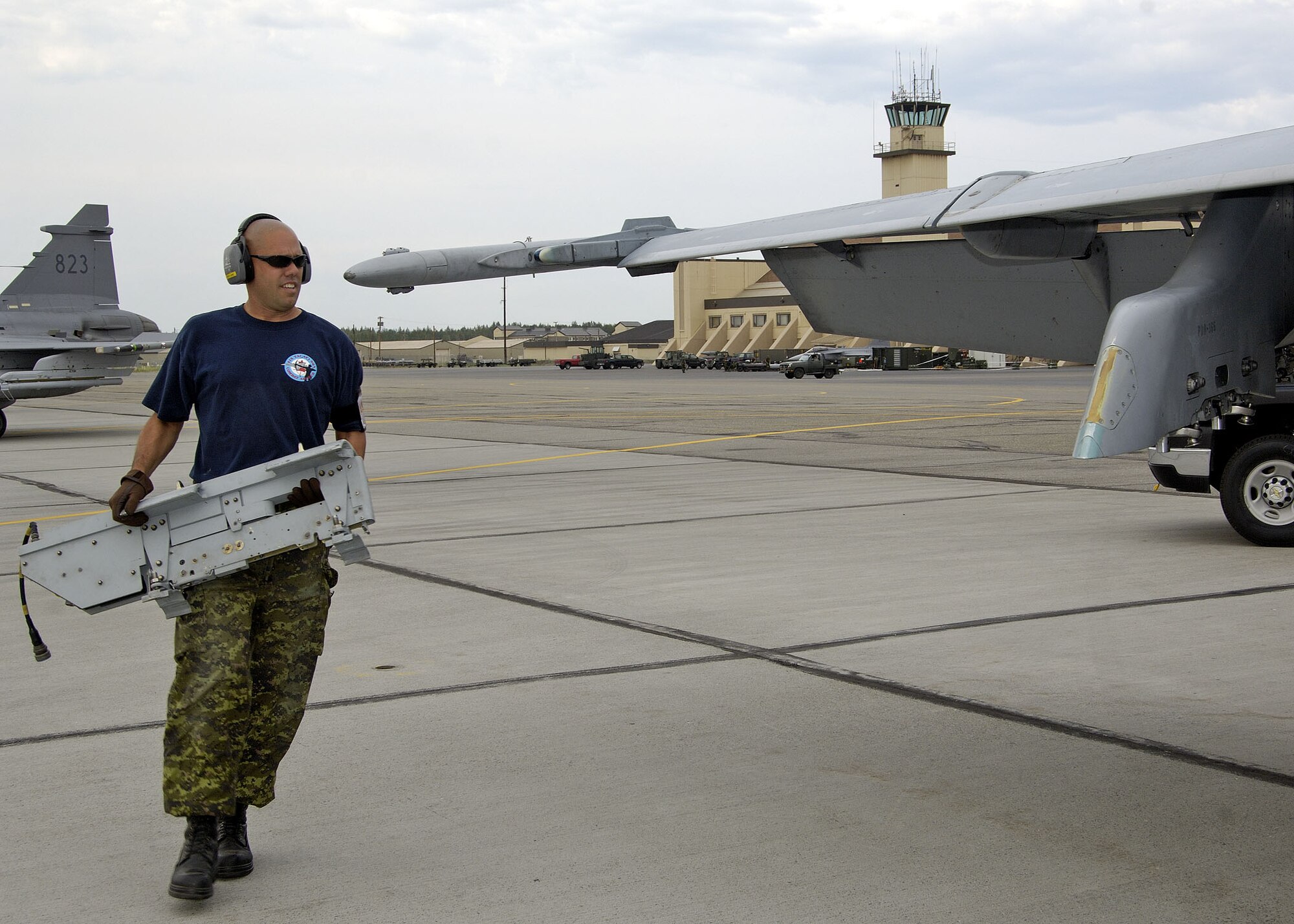 EIELSON AIR FORCE BASE, Alaska - Corporal (Cpl) Luc Savoie, an Avionics Technician at 409 Tactical Fighter Squadron carries a bomb rack over to a waiting CF-18. Cpl Kuhl, a native of Owen Sound On. is a participant in Excersise Co-operative Cope Thunder 06-3 (CCT06-3). CCT06-3 is an annually run excersise with missions being flown out of both Eielson and Elmendorf Air Force Base (AFB), Alaska from Jul 20 - Aug 5 2006. Excersise participants this year include Canada the United States, Japan, Sweden, Nato, Mongolia, South Korea, Germany, the Slovak Republic, and Australia. Observer nations include Mexico, Bangladesh, Sri Lanka Malaysia, and Russia. Approximately 1300 service personnel are participating, about 800 of those from the host nation. Photo by Cpl J.A. Wilson, CCT06-3 Canadian Public Affairs