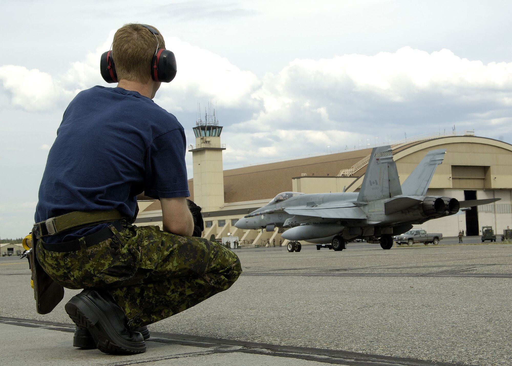 EIELSON AIR FORCE BASE, Alaska - Corporal (Cpl) Adam Kuhl, an Aviation Technician at 409 Tactical Fighter Squadron watches as a CF-18 taxis by on its way to the PM launch. Cpl Kuhl, a native of Owen Sound On. is a participant in Excersise Cooperative Cope Thunder 06-3 (CCT06-3). CCT06-3 is an annually run excersise with missions being flown out of both Eielson and Elmendorf Air Force Base (AFB), Alaska from Jul 20 - Aug 5 2006. Excersise participants this year include Canada the United States, Japan, Sweden, Nato, Mongolia, South Korea, Germany, the Slovak Republic, and Australia. Observer nations include Mexico, Bangladesh, Sri Lanka Malaysia, and Russia. Approximately 1300 service personnel are participating, about 800 of those from the host nation. Photo by Cpl J.A. Wilson, CCT06-3 Canadian Public Affairs