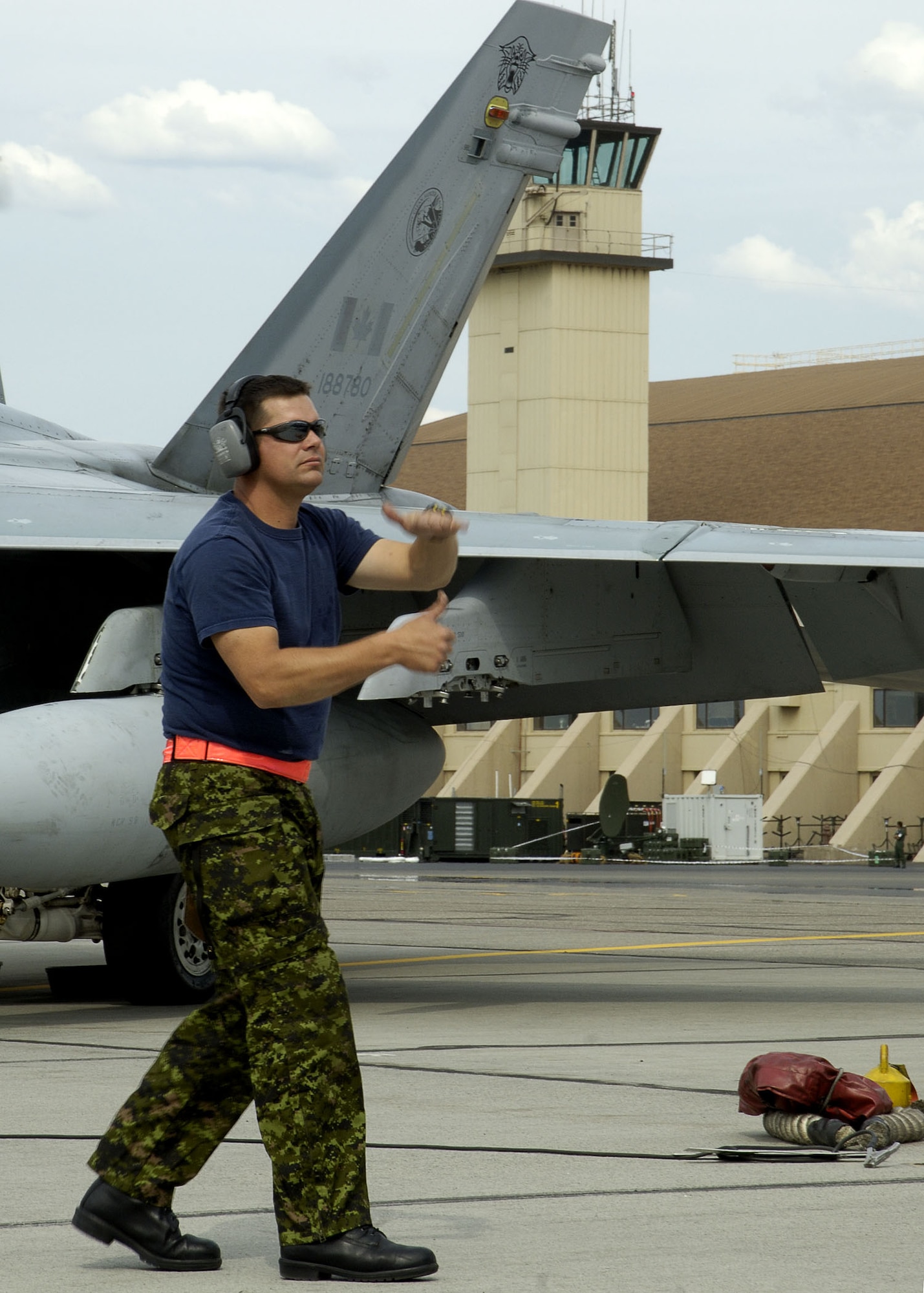 EIELSON AIR FORCE BASE, Alaska - Corporal (Cpl) Adam Vandenberg, an Aviation Technician from 409 Tactical Fighter Squadron uses hand motions to signal to the pilot of the CF-18 he is praparing to launch. Cpl Vandenberg, a native of Brandon On. is a participant in Excersise Cooperative Cope Thunder 06-3 (CCT06-3). CCT06-3 is an annually run excersise with missions being flown out of both Eielson and Elmendorf Air Force Base (AFB), Alaska from Jul 20 - Aug 5 2006. Excersise participants this year include Canada the United States, Japan, Sweden, Nato, Mongolia, South Korea, Germany, the Slovak Republic, and Australia. Observer nations include Mexico, Bangladesh, Sri Lanka Malaysia, and Russia. Approximately 1300 service personnel are participating, about 800 of those from the host nation. Photo by Cpl J.A. Wilson, CCT06-3 Canadian Public Affairs