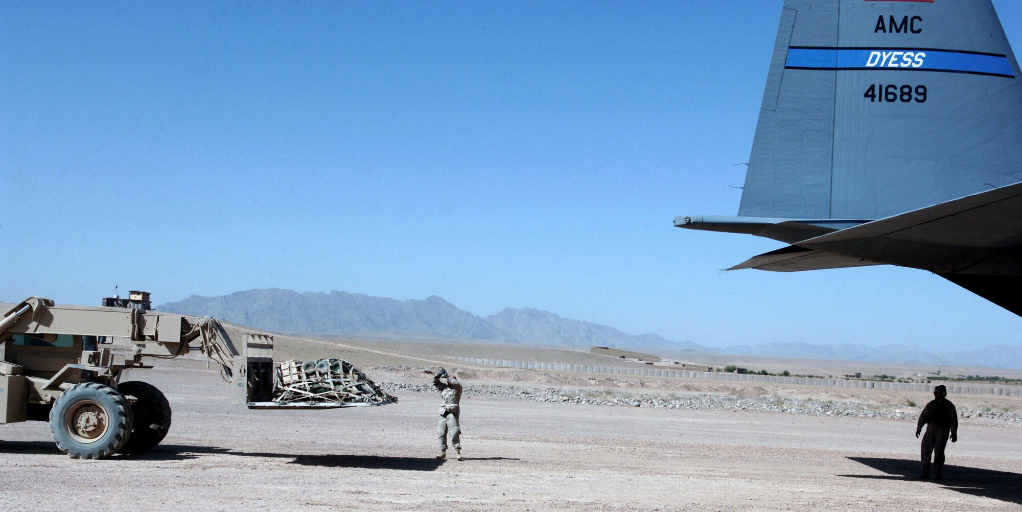 Tech. Sgt. Philip Lester directs a forklift as it carries a cargo pallet to an waiting C-130 Hercules. Sergeant Lester is assigned to an Army unit in Tarin Kowt, Afghanistan. (U.S. Air Force photo/Master Sgt. Orville F. Desjarlais Jr.)