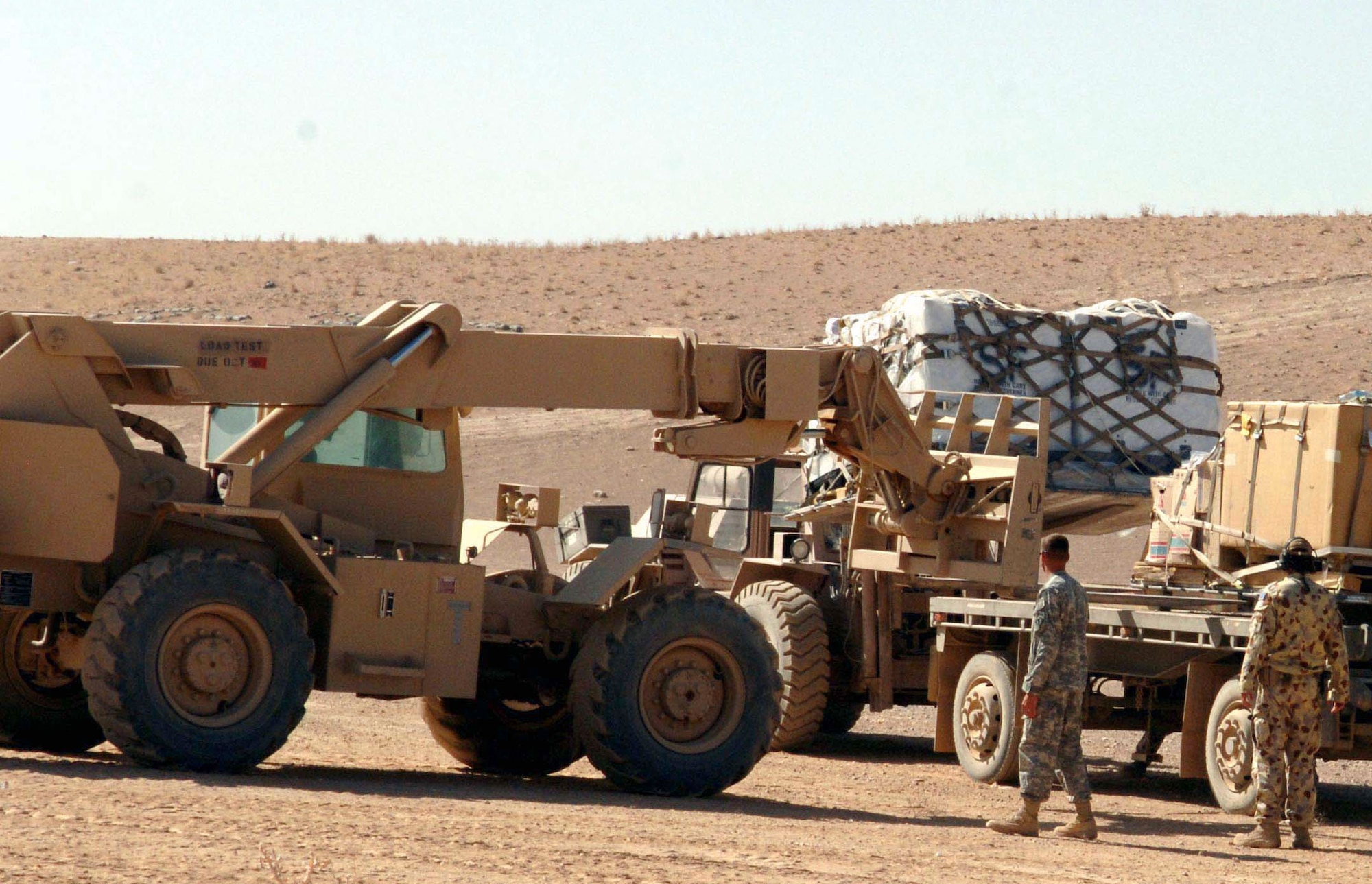 Tech. Sgt. Philip Lester uses a forklift to unload a cargo pallet onto an Army truck while an Australian airman looks on. Sergeant Lester is assigned to an Army unit in Tarin Kowt, Afghanistan. (U.S. Air Force photo/Master Sgt. Orville F. Desjarlais Jr.)