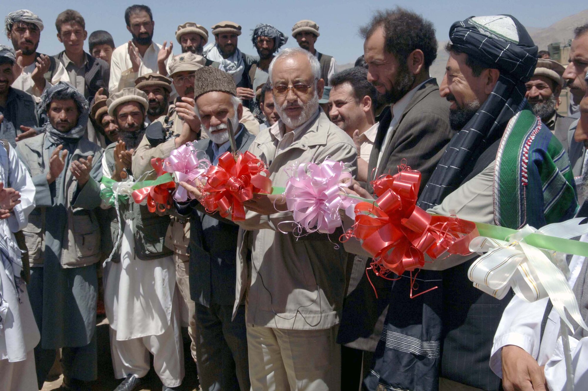 JABAL SARAJ, Afghanistan -- Parwan Province Governor Abdul Jabar Taqwa cuts a ribbon to cermoniously open a new bridge and improved road in this district. The Bagram Provincial Reconstruction Team helped improve a road and build a two-way bridge here.


