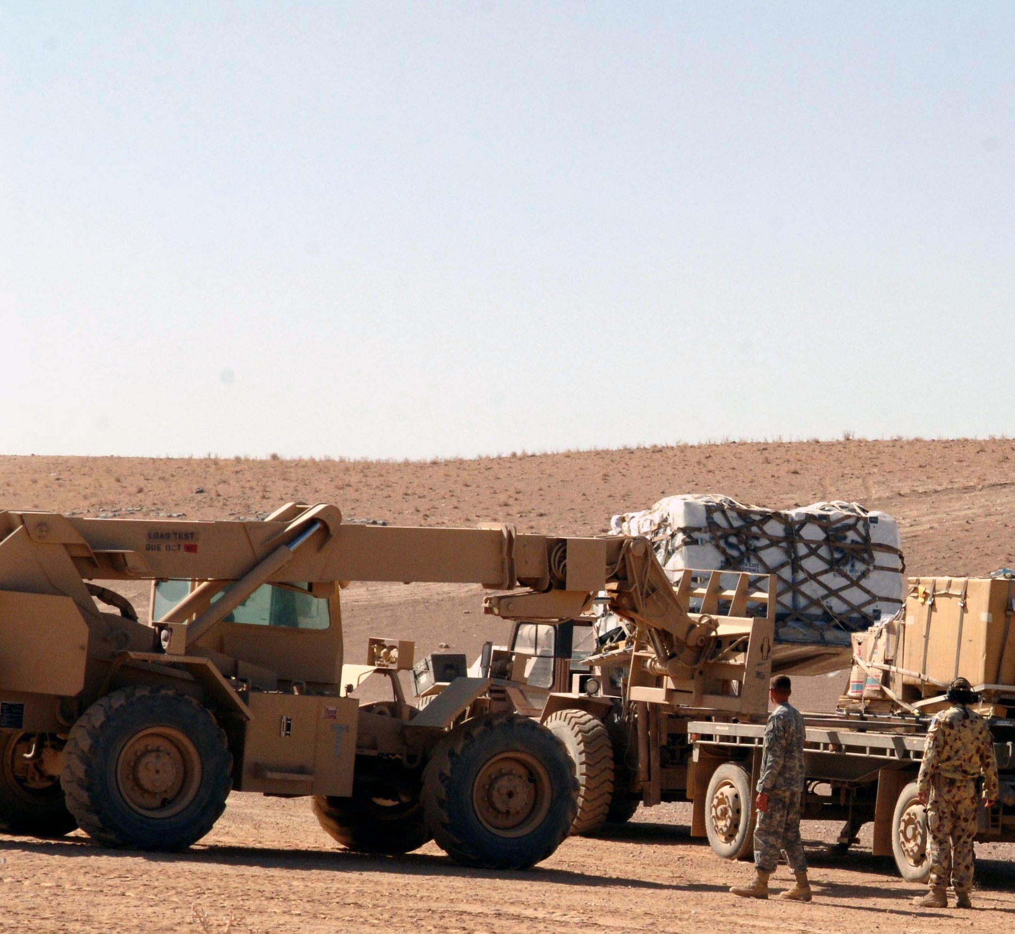 Tech. Sgt. Philip Lester uses a forklift to unload a cargo pallet onto an Army truck while an Australian airman looks on.  Sergeant Lester is assigned to an Army unit in Tarin Kowt, Afghanistan.