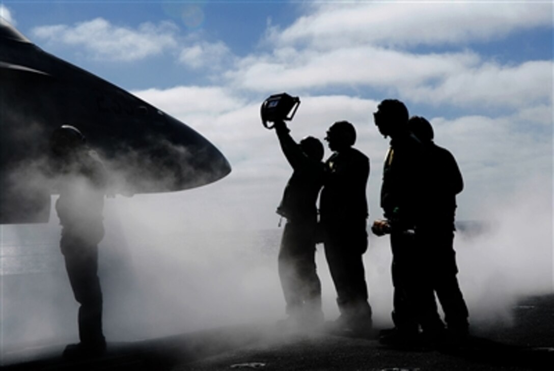 A U.S. Navy crewmember shows pilots the weight of an awaiting aircraft prior to launching from the flight deck of the Nimitz-class aircraft carrier USS John C. Stennis currently undwerway for carrier qualifications in the Pacific Ocean off the coast of Southern California, July 11, 2006. 