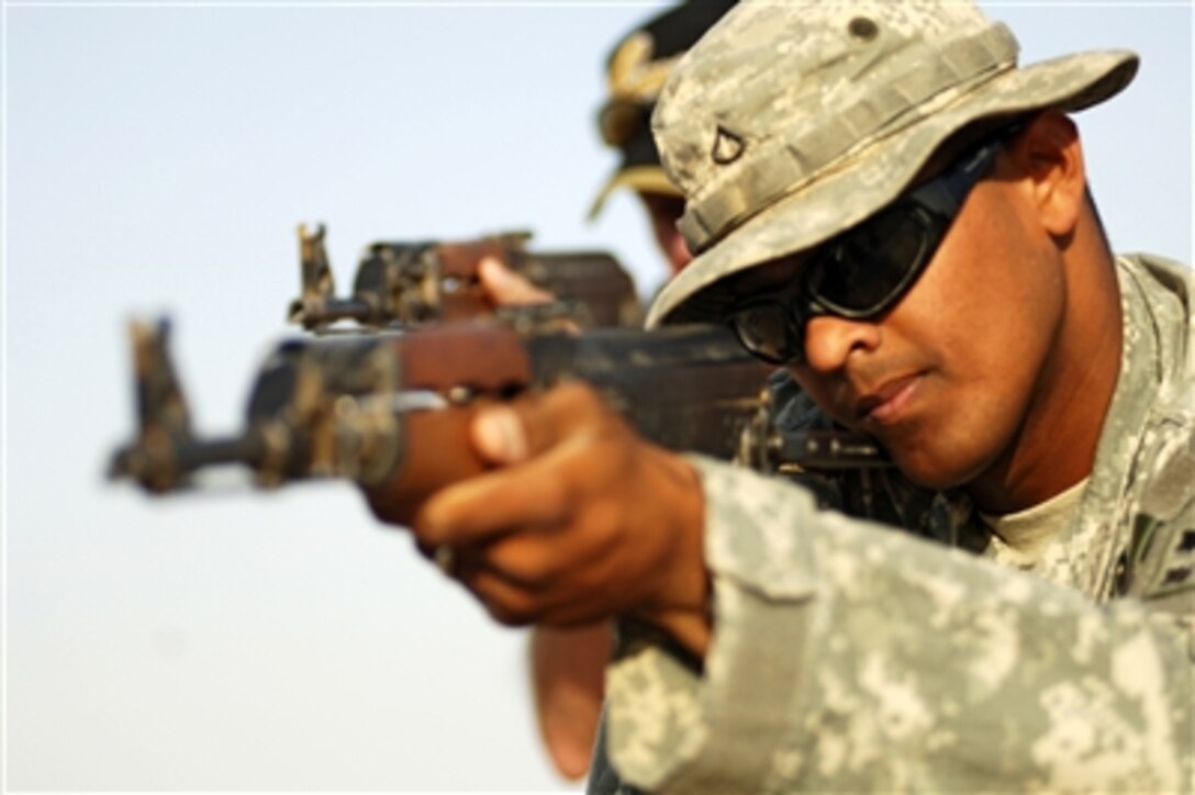 A U.S. Army soldier demonstrates how to properly clear a hallway for Iraqi police recruits during a hallway clearing scenario at Forward Operating Base Duke, Iraq, July 4, 2006. Iraqi police recruits go through a two-week training course called The Crucible, which is conducted by the U.S. Army's 3rd Battalion, 16th Field Artillery Regiment and civilian contractors. 