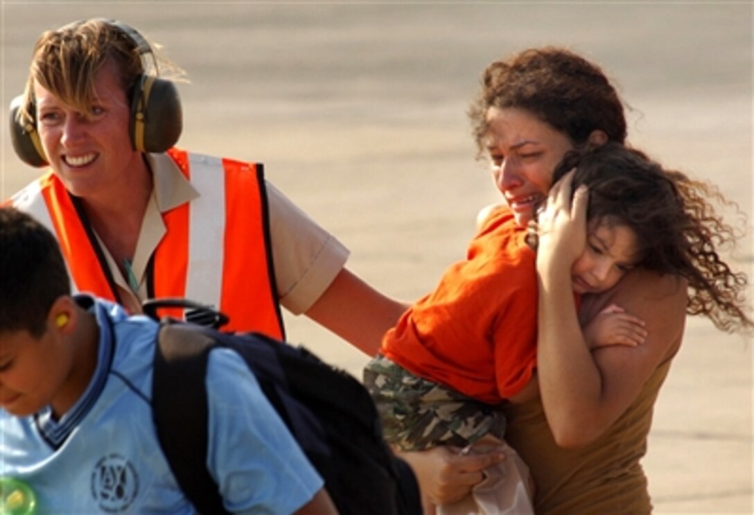 A woman and her child are guided to the terminal as they exit a U.S. Marine Corps CH-53 Super Stallion helicopter at Cyprus following their flight from the U.S. Embassy in Beirut, Lebanon, on July 17, 2006. At the request of the U.S. Ambassador to Lebanon and at the direction of the U.S. Defense Secretary, the United States Central Command and 24th Marine Expeditionary Unit are assisting with the departure of U.S. citizens from Lebanon. The helicopters are attached to Marine Medium Helicopter Sq