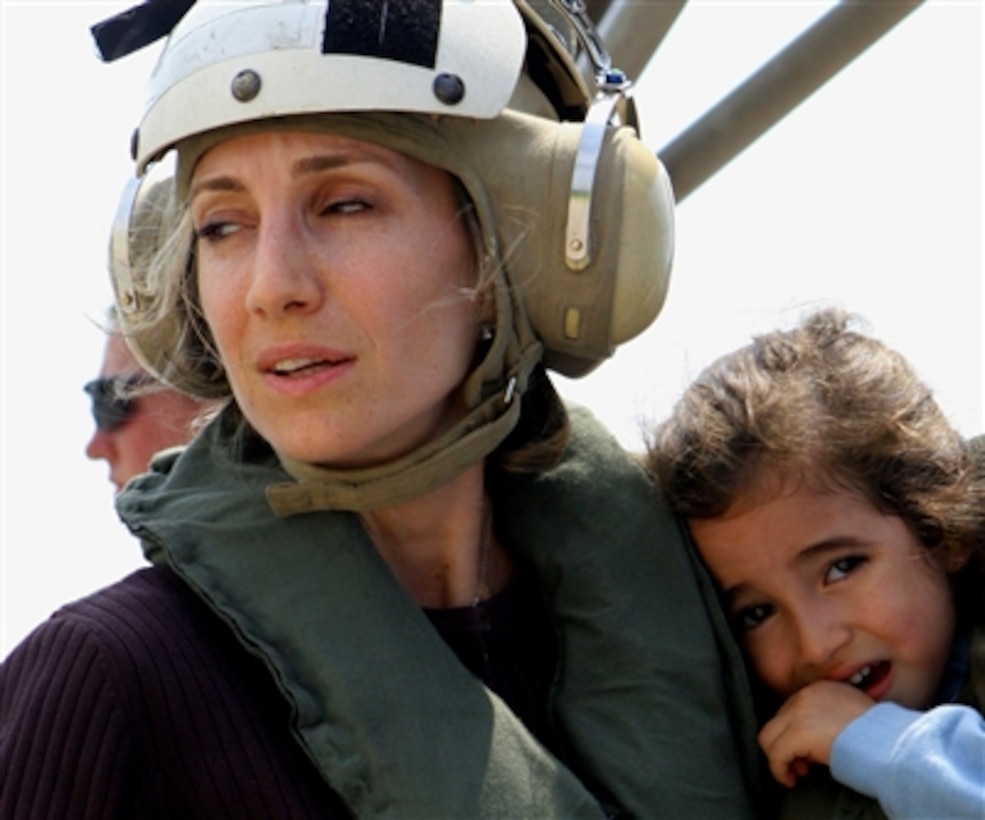 A U.S. citizen holds a child as they wait to board a U.S. Marine Corps CH-53 Super Stallion helicopter at the U.S. Embassy in Beirut, Lebanon, for a flight to Cyprus on July 19, 2006. 