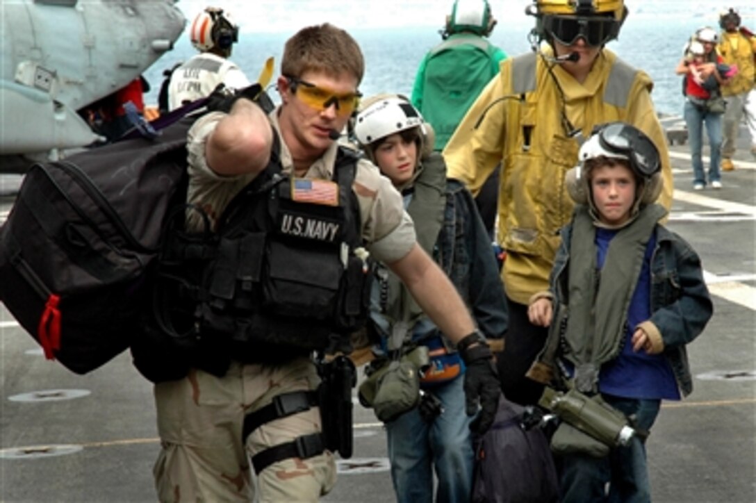 U.S. Navy sailors from the USS Trenton assist two young American citizens departing Lebanon, July 21, 2006. 