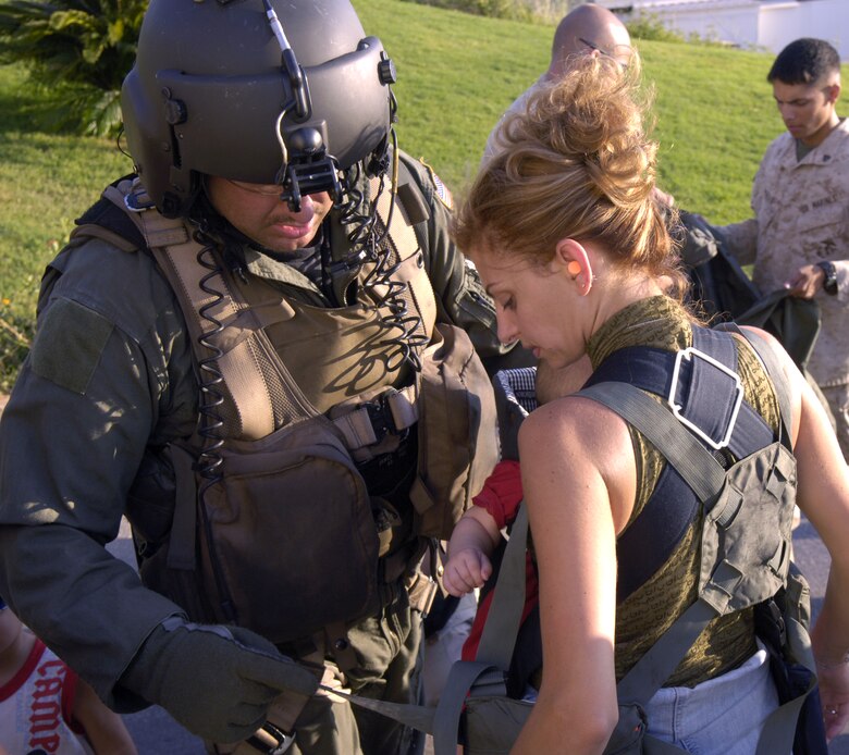 BEIRUT, Lebanon (AFPN) -- Tech. Sgt. Jim Gary helps lace a life preserver on Carole Souaidan before boarding an MH-53M Pave Low helicopter at the U.S. Embassy here July 24. Sergeant Gary is an aerial gunner with the 352nd Special Operations Group at Royal Air Force Mildenhall, England. (U.S. Air Force photo/Senior Airman Brian Ferguson)