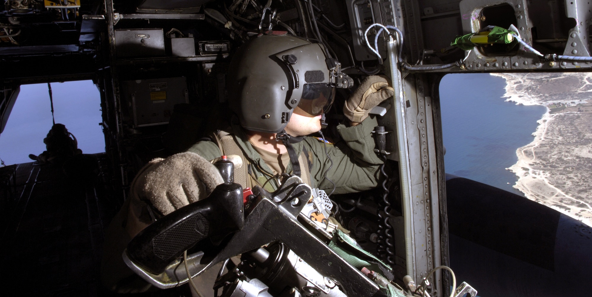 CYPRUS (AFPN) -- Tech. Sgt. John Stott checks the left side of a MH-53M Pave Low helicopter in flight July 24. Sergeant Stott is an aerial gunner with the 352nd Special Operations Group at Royal Air Force Mildenhall, England, and is deployed here to help with the transportation of American citizens from Lebanon. (U.S. Air Force photo/Senior Airman Brian Ferguson)