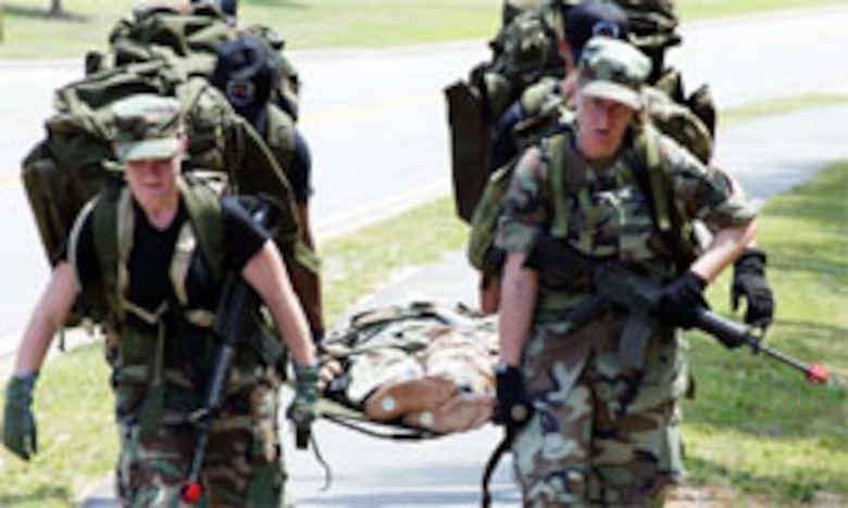 Members of Team 3 push their limits to bring their patient back to the squadron after their ruck march. All of the teams battled the heat and each other?s times to complete the squadron challenge?s events. (U.S. Air Force photo/Lisa Terry McKeown)
