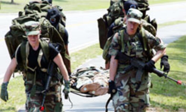 Members of Team 3 push their limits to bring their patient back to the squadron after their ruck march. All of the teams battled the heat and each other?s times to complete the squadron challenge?s events. (U.S. Air Force photo/Lisa Terry McKeown)