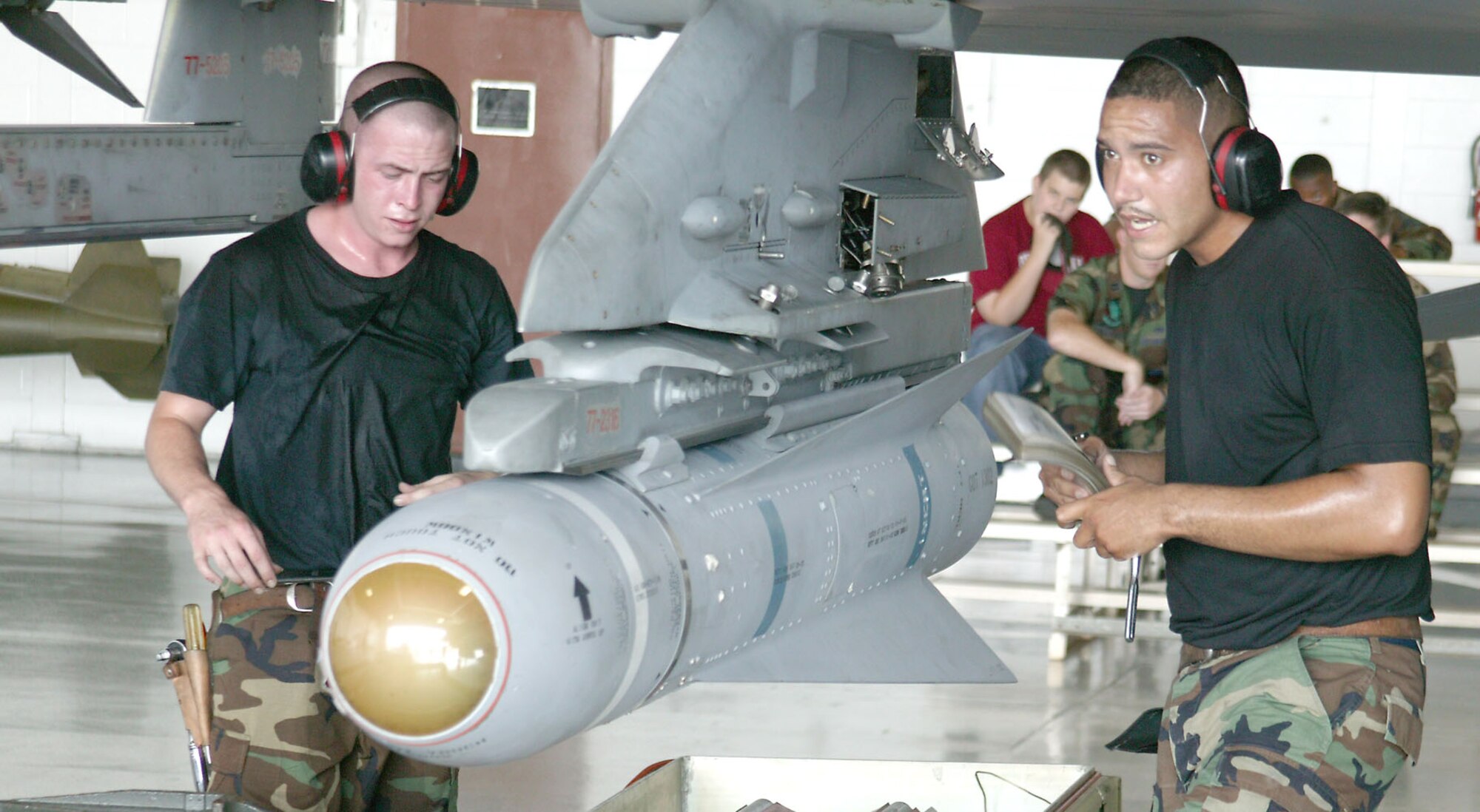 Staff Sgt. Jeffrey Meszaros (right) and Senior Airman Bert Lowry, 77th Aircraft Maintenance Unit weapons loaders, compete in the quarterly AMU Load Competition July 21. Crews competed in temperatures exceeding 100 degrees. The 77th AMU was declared the winner.  (U.S. Air Force photo/Senior Airman John Gordinier)