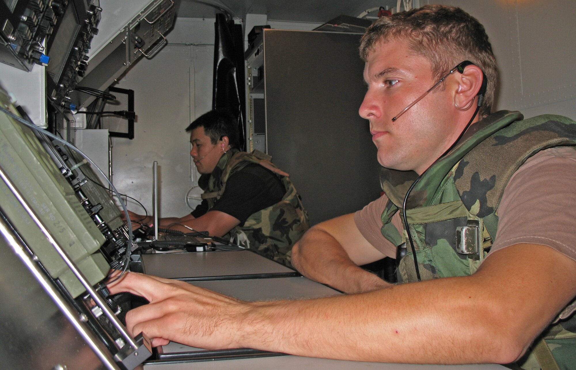 BARBER?S POINT, Hawaii -- Tech. Sgt. Daniel Keefe and Tech. Sgt. William Chang monitor RADAR screens during an exercise at Barber's Point, Hawaii, on 25 July, 2006.  Both Airmen are with the Hawaii Air National Guard's 297th Air Traffic Control Squadron. (US Air Force Photo by Tech. Sgt. Chris Vadnais)