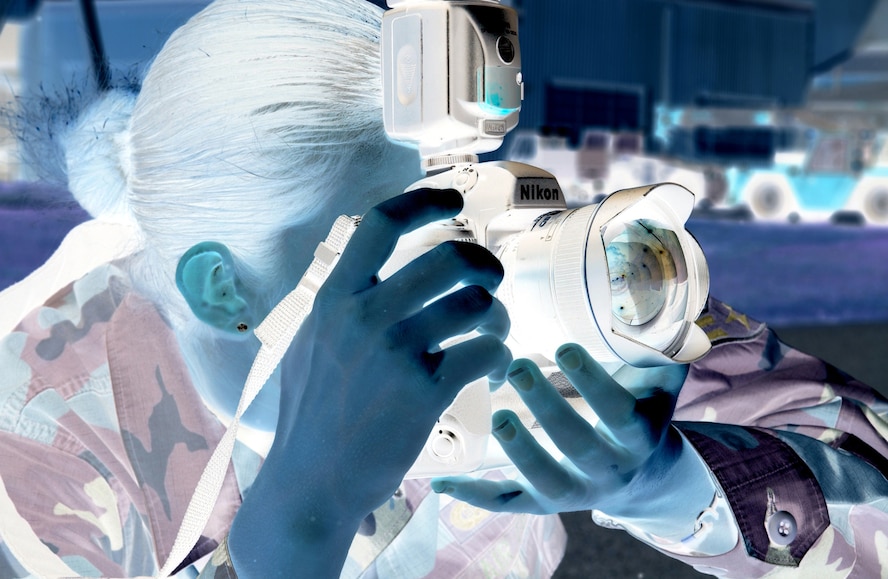 Airman 1st Class Stephanie Sinclair, 16th Communications Squadron, photographs airmen performing duties on the flightline here Tuesday. The exposure has been inverted to a negative. (Air Force Photograph by Airman 1st Class Danielle Morrow; edited by Dylan Laurie) 
 
