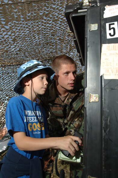 Hunter Tregstad is shown how to hunt down bad guys with a simulator by Specialist Sean Hangen, Bravo Battery, North Dakota National Guard during the Thunder over the Red River air show here Saturday. The “Thunder over the Red River” Air Show is the 26th air show on this years schedule opening Grand Forks Air Force Base to an estimated 40,000 spectators from the surrounding community. The event highlighted multiple static displays as well as feature demonstrations from the Air Force Thunderbirds and the Army Black Dagger parachute demonstration team. (Photo by Staff Sgt. Suellyn Nuckolls.)