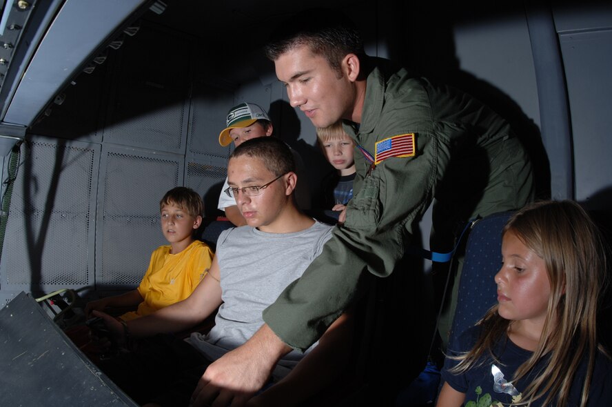 Senior Airman Casey Mondragon, 9th Air Refueling Squadron, Travis Air Force Base, Calif., shows children the refueling pod inside of a KC-10 Extender during the air show here Saturday. (Photos by Staff Sgt. Suellyn Nuckolls.)