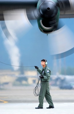 Korean air force Senior Master Sgt. Bumsoo Shin monitors engine startup on a C-130 at Elmendorf Air Force Base, Alaska, on July 25. The Korean air force and other multi-national aircrews are in Alaska participating in the Pacific Air Forces exercise Cooperative Cope Thunder. (U.S. Air Force photo/Senior Airman Garrett Hothan)