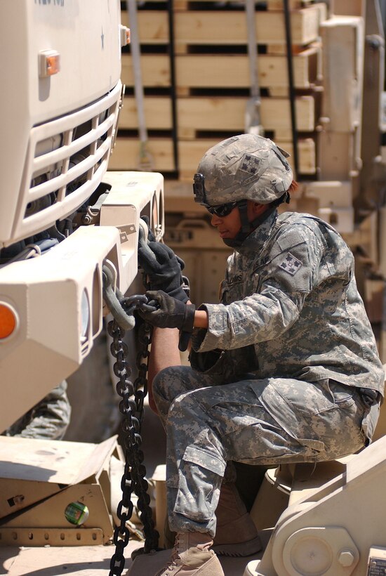 Army Sgt. Laura Williams, a truck driver with Company A, 204th Support Battalion, 2nd Brigade Combat Team, 4th Infantry Division, ties down an M1088 truck to the bed of a M1000 heavy-equipment trailer July 16 at Forward Operating Base Duke. Soldiers from 204th SB are moving their base of operations north to Forward Operating Base Kalsu. FOB Duke is set to be transferred to Iraqi forces. Photo by Cpl. Michael Molinaro, USA