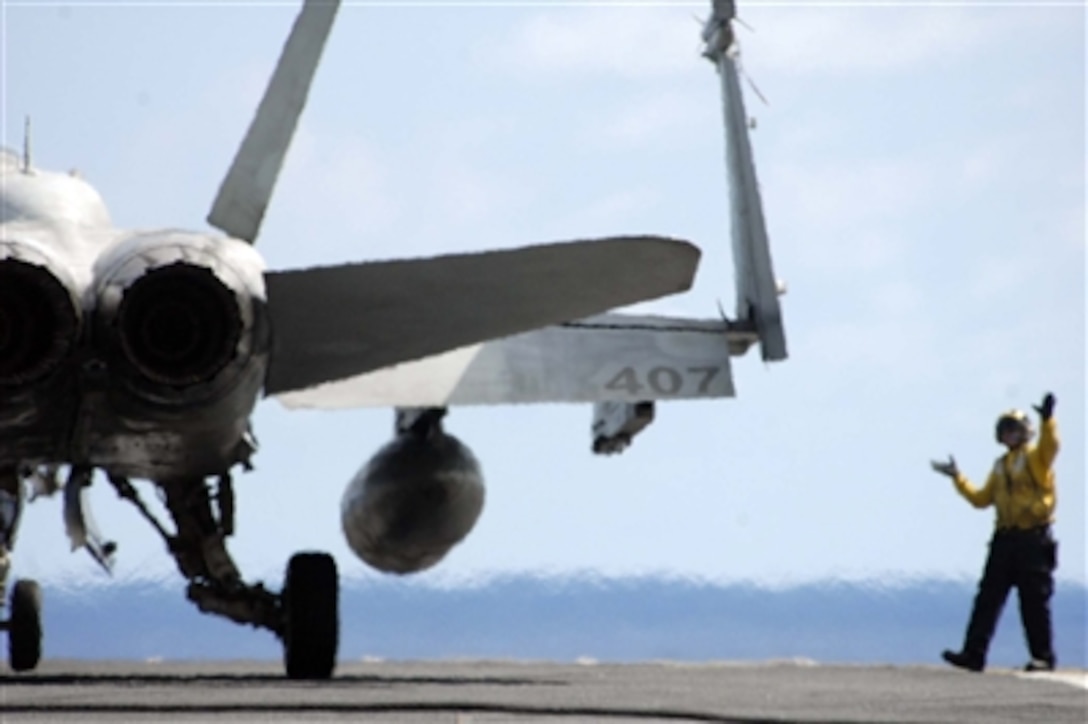 A U.S. Navy flight deck crewman directs an F/A-18C Hornet aircraft aboard the USS Abraham Lincoln (CVN 72) prior to launch on July 20, 2006. The Abraham Lincoln Carrier Strike Group is under way in the Hawaiian operations area participating in exercise Rim of the Pacific 2006, which includes ships and personnel from the United States, Australia, Canada, Chile, Japan, Peru, the Republic of Korea, and the United Kingdom. 