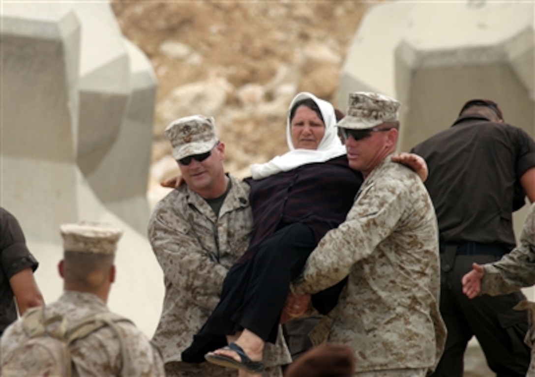 U.S. Marines from the Marine Expeditionary Unit Service Support Group 24 carry a woman aboard a landing craft utility with other American citizens in Beirut, Lebanon, on July 21, 2006. At the request of the U.S. Ambassador to Lebanon and at the direction of the Secretary of Defense, the United States Central Command and elements of Task Force 59 are assisting with the departure of U.S. citizens from Lebanon. 