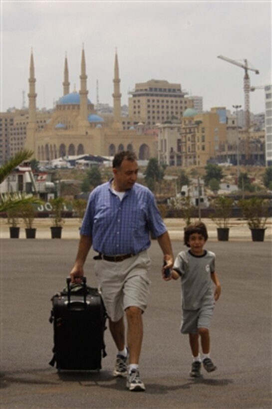 A U.S. citizen and child walk to the boarding area for the cruise ship Orient Queen in Beirut, Lebanon, for transport to Cyprus on July 19, 2006. The ship, under contract with the U.S. government, is part of the larger U.S. military mission to assist U.S. citizens in their departure from Lebanon.