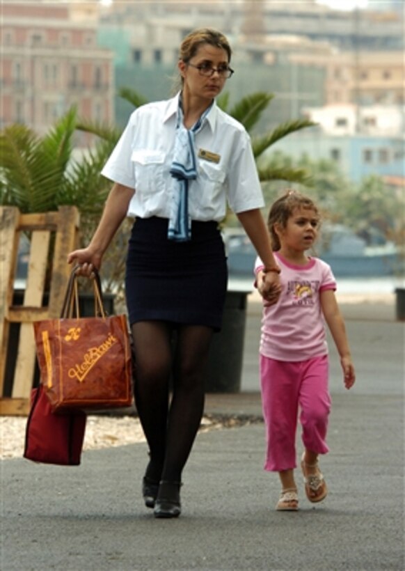 A U.S. citizen and child walk to the boarding area for the cruise ship Orient Queen in Beirut, Lebanon, for transport to Cyprus on July 19, 2006. The ship, under contract with the U.S. government, is part of the larger U.S. military mission to assist U.S. citizens in their departure from Lebanon.