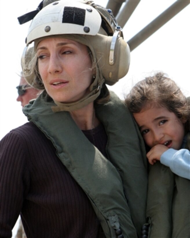 A U.S. citizen holds a child as they wait to board a U.S. Marine Corps CH-53 Super Stallion helicopter at the U.S. Embassy in Beirut, Lebanon, for a flight to Cyprus on July 19, 2006. At the request of the U.S. Ambassador to Lebanon and at the direction of the Secretary of Defense, the United States Central Command and 24th Marine Expeditionary Unit are assisting with the departure of U.S. citizens from Lebanon. 