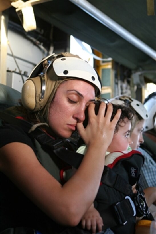 An American woman calms a child while flying in a U.S. Marine Corps CH-53 Super Stallion helicopter from the U.S. Embassy in Beirut, Lebanon, to Royal Air Force Base Akrotiri in Cyprus on July 18, 2006. At the request of the U.S. Ambassador to Lebanon and at the direction of the Secretary of Defense, the United States Central Command and 24th Marine Expeditionary Unit are assisting with the departure of U.S. citizens from Lebanon. The helicopters are attached to Marine Medium Helicopter Squadron 365. 