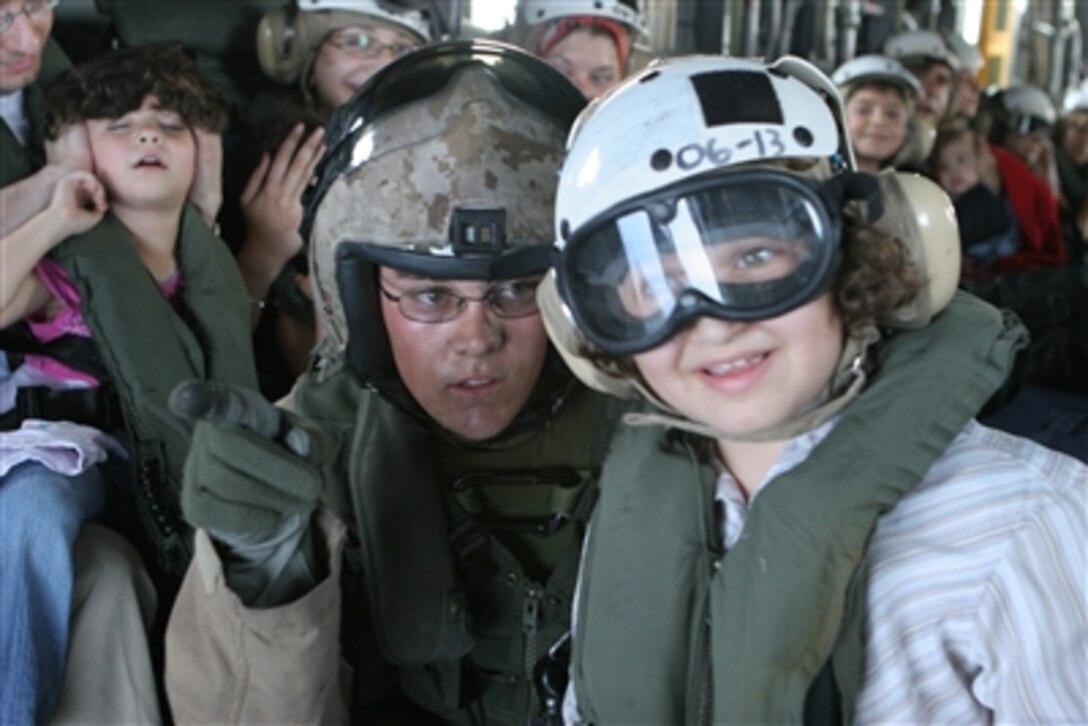 A Marine aircrewman helps a child look out the open door of a U.S. Marine Corps CH-53 Super Stallion helicopter while flying from the U.S. Embassy in Beirut, Lebanon, to Royal Air Force Base Akrotiri in Cyprus on July 18, 2006. At the request of the U.S. Ambassador to Lebanon and at the direction of the Secretary of Defense, the United States Central Command and 24th Marine Expeditionary Unit are assisting with the departure of U.S. citizens from Lebanon. The helicopters are attached to Marine Medium Helicopter Squadron 365.