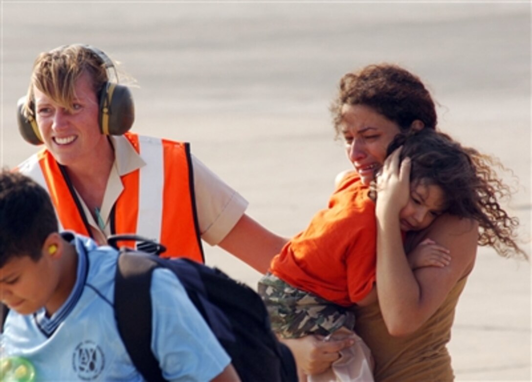 A woman and her child are guided to the terminal as they exit a U.S. Marine Corps CH-53 Super Stallion helicopter at Royal Air Force Base Akrotiri in Cyprus following their flight from the U.S. Embassy in Beirut, Lebanon, on July 17, 2006. At the request of the U.S. Ambassador to Lebanon and at the direction of the Secretary of Defense, the United States Central Command and 24th Marine Expeditionary Unit are assisting with the departure of U.S. citizens from Lebanon. The helicopters are attached to Marine Medium Helicopter Squadron 365. 