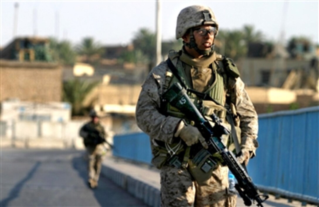 U.S. Marine Corps Sgt. Rafael Perez, from Kilo Company, 3rd Battalion, 3rd Marine Regiment, patrols through Haqlaniyah, Iraq, July 22, 2006. 