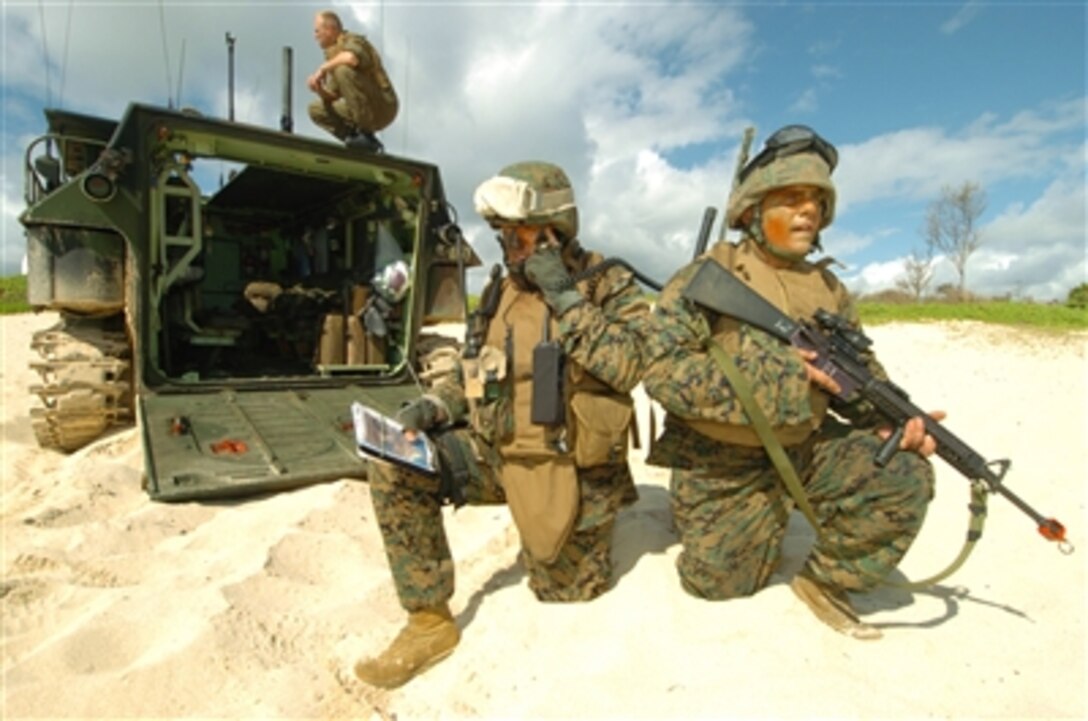 U.S. Marine Corps Capt. Jon Curtis (left) calls in an air strike as Cpl. Eric Brookes provides security as part of a simulated beach assault on Kaneohe Bay Marine Corps Base, Hawaii, July 18, 2006, during exercise Rim of the Pacific 2006. The exercise, commonly called RIMPAC, brings together military forces from Australia, Canada, Chile, Peru, Japan, the Republic of Korea, the United Kingdom and the United States in the world's largest biennial maritime exercise. Curtis and Brookes are attached to the Fire Support Team with Echo Company, 1st Marine Regiment. 