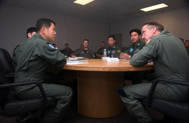 ELMENDORF AIR FORCE BASE, Alaska -- Col. Greg Nelson, Cooperative Cope Thunder/Red Flag Alaska?s Air Expeditionary Group commander (center), Col. Jeongkyu Woo, commander from the Republic of Korea Air Force (left), and Col. Mutsumi Fukushima, commander from the Japanese Air Self Defense Force (right), exchange background information and discuss the significance of Cooperative Cope Thunder during a meeting. (U.S. Air Force Photo by Senior Airman Garrett Hothan)(RELEASED)

