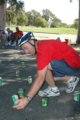 A participant in the “Amazing Race” picks up a can, looking for his team’s number. The 615th Contingency Response Wing put on the race to combine physical skill, mental toughness and problem solving in the spirit of friendly competition.