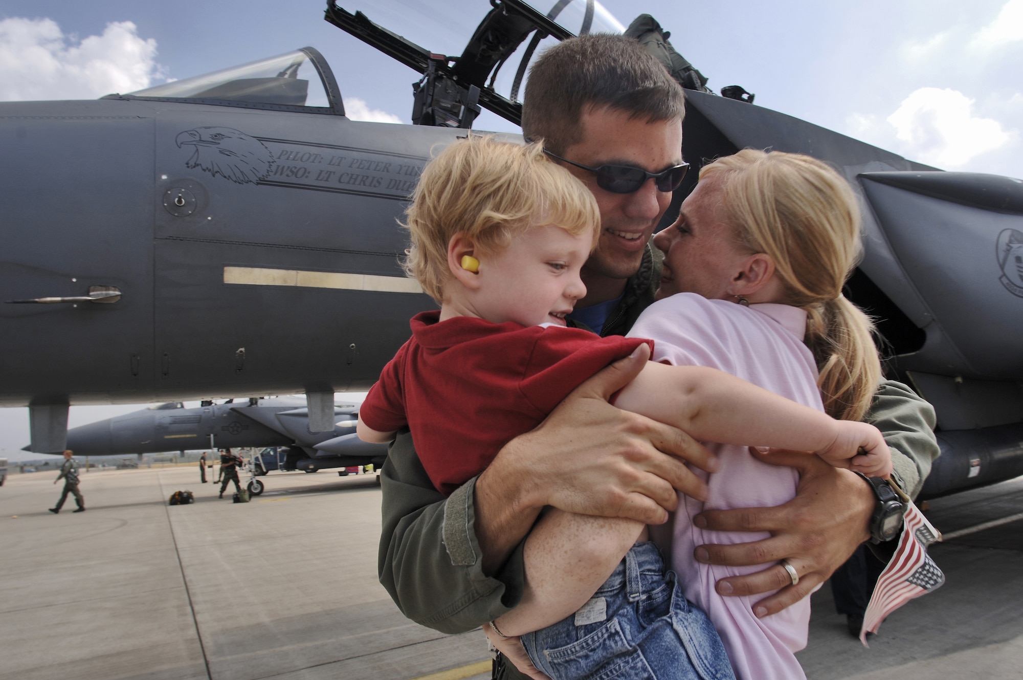 Capt. Martin Hemmingsen hugs his wife, Aimee, right, and their 3-year-old son Mitchell, during his return to Royal Air Force Lakenheath, England, on Friday, July 28. The 492nd Fighter Squadron jets were returning home from a two-week deployment to Graf-Isnatievo Air Base, Bulgaria, where they took part in exercise Immediate Response, which began July 17. Airmen from the 48th Fighter Wing provided support at the joint, trilateral exercise with the Bulgarian and Romanian militaries and U.S. Soldiers. The Airmen practiced ground attack and air-to-air tactics. (U.S. Air Force photo/Master Sgt. Lance Cheung)