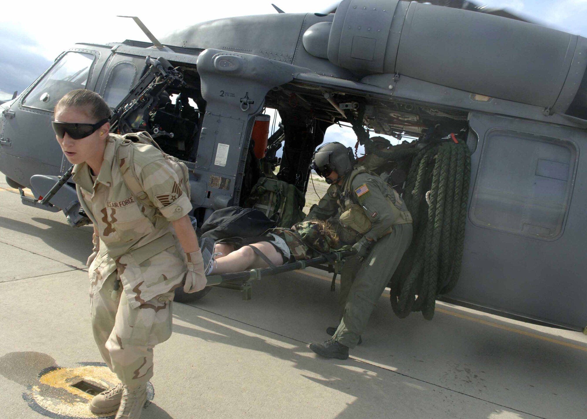 Tech. Sgt. Gwen Wear (left) and an aerial gunner unload a simulated mass casualty survivor out of a HH-60 Pavehawk July 27 as part of exercise Angel Thunder. Angel Thunder is a five-day exercise held at and around Davis-Monthan Air Force Base, Ariz. It is designed to provide realistic, full-spectrum recovery training for Air Force active-duty, Guard and Reserve combat rescue forces. Sergeant Wear is with the 58th Rescue Squadron. (U.S. Air Force photo/Senior Airman Christina D. Ponte)