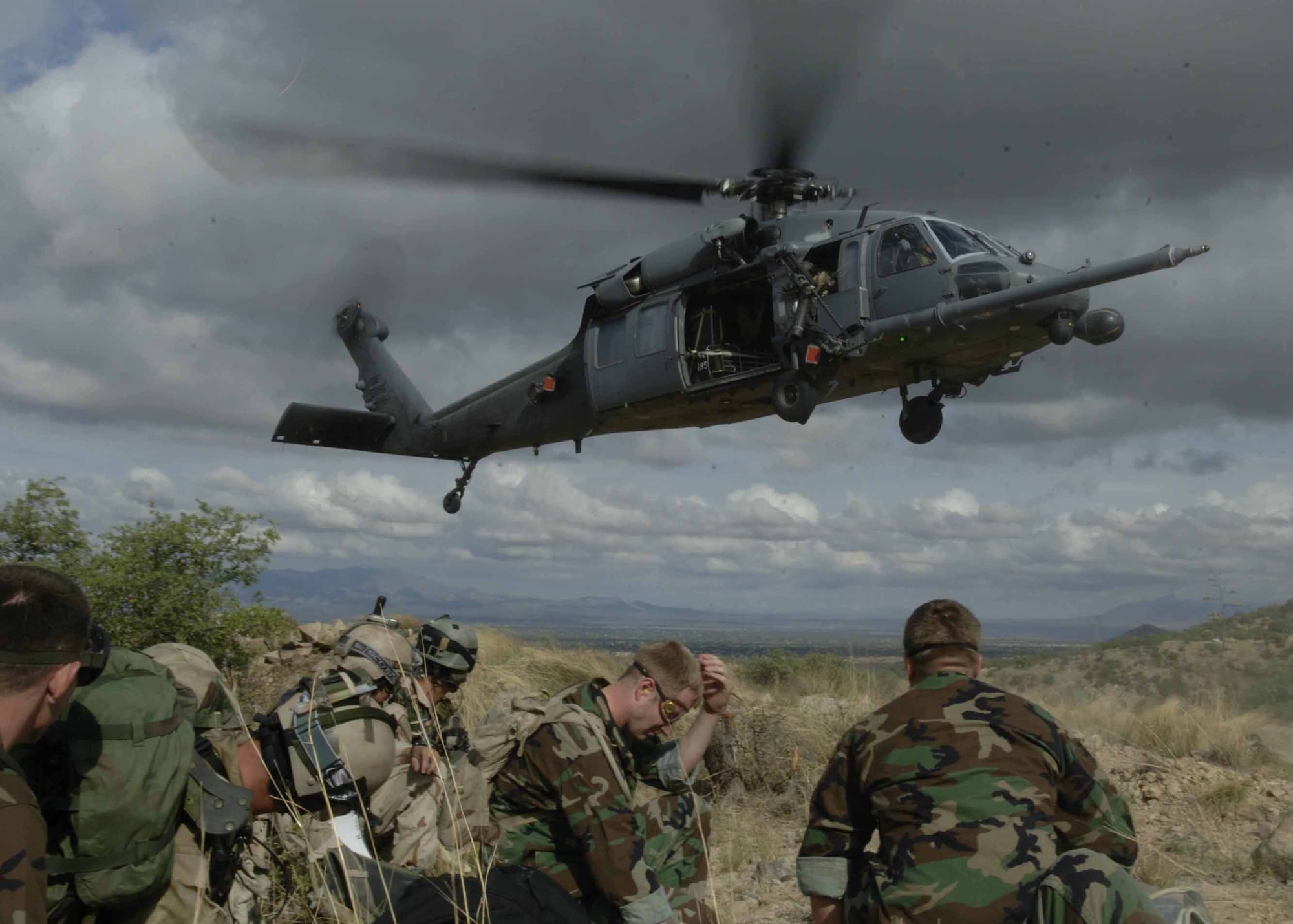 Pararescuemen and simulated mass casualty survivors take cover as a HH-60 Pavehawk lands July 27 as part of exercise Angel Thunder. The survivors were flown to Davis-Monthan Air Force Base to a simulated level 2/3 medical facility. (U.S. Air Force photo/Senior Airman Christina D. Ponte)