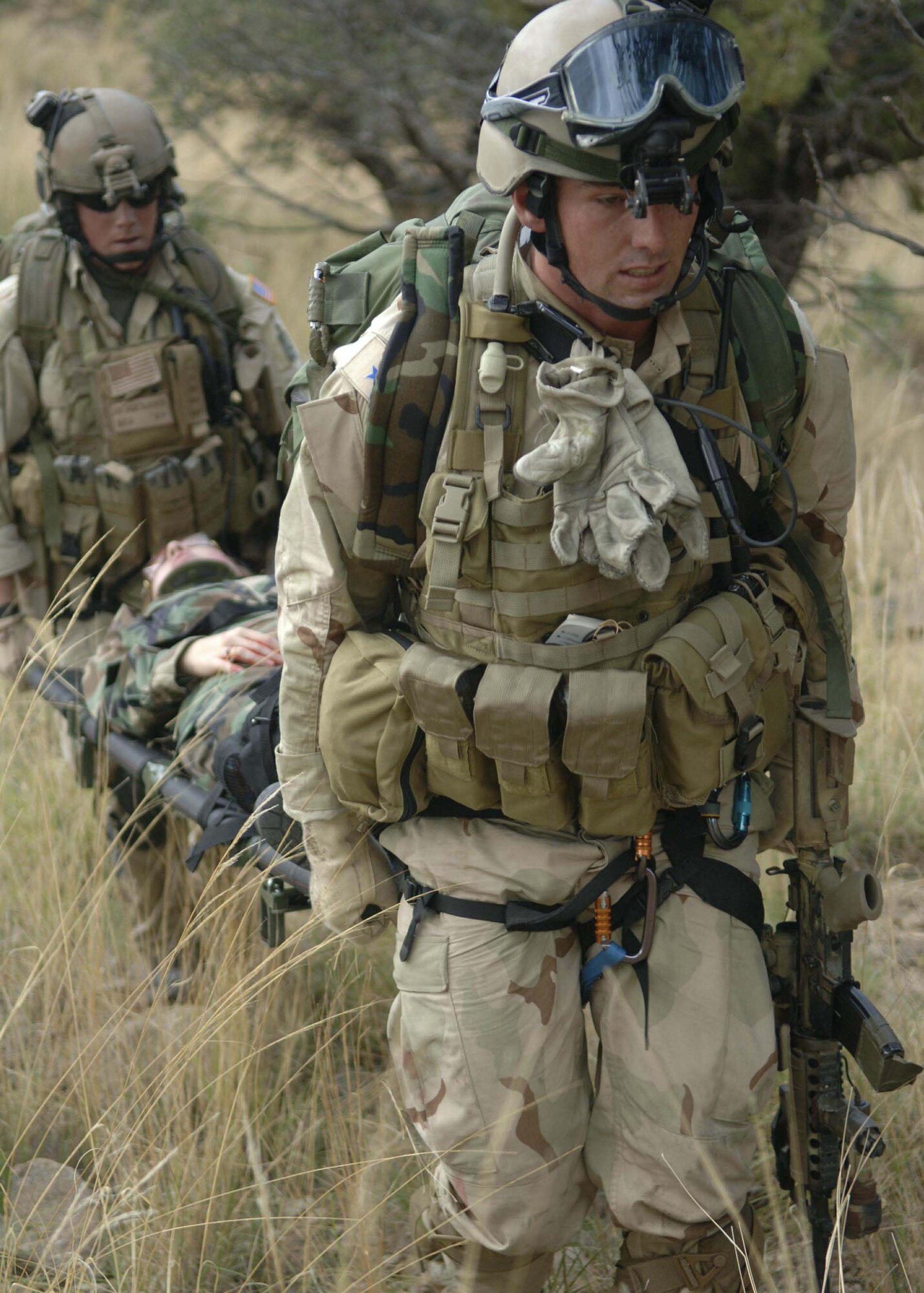 Senior Airman Corey Farr and Senior Airman Jonathan McKenzie carry a simulated mass casualty survivor to a safe location July 27 as part of exercise Angel Thunder. The mass casualty scenario involved two CH-47 Chinook helicopters crashing. Once on the ground, pararescuemen triaged survivors and relocated them to a casualty collection point. They were then flown to Davis-Monthan Air Force Base to a simulated level 2/3 medical facility. This part of exercise Angel Thunder involved the 48th, 58th, 66th, 79th and 305th Rescue Squadrons as well as air support from the 358th Fighter Squadron. Airman Farr and Airman McKenzie are with the 58th Rescue Squadron. (U.S. Air Force photo/Senior Airman Christina D. Ponte)