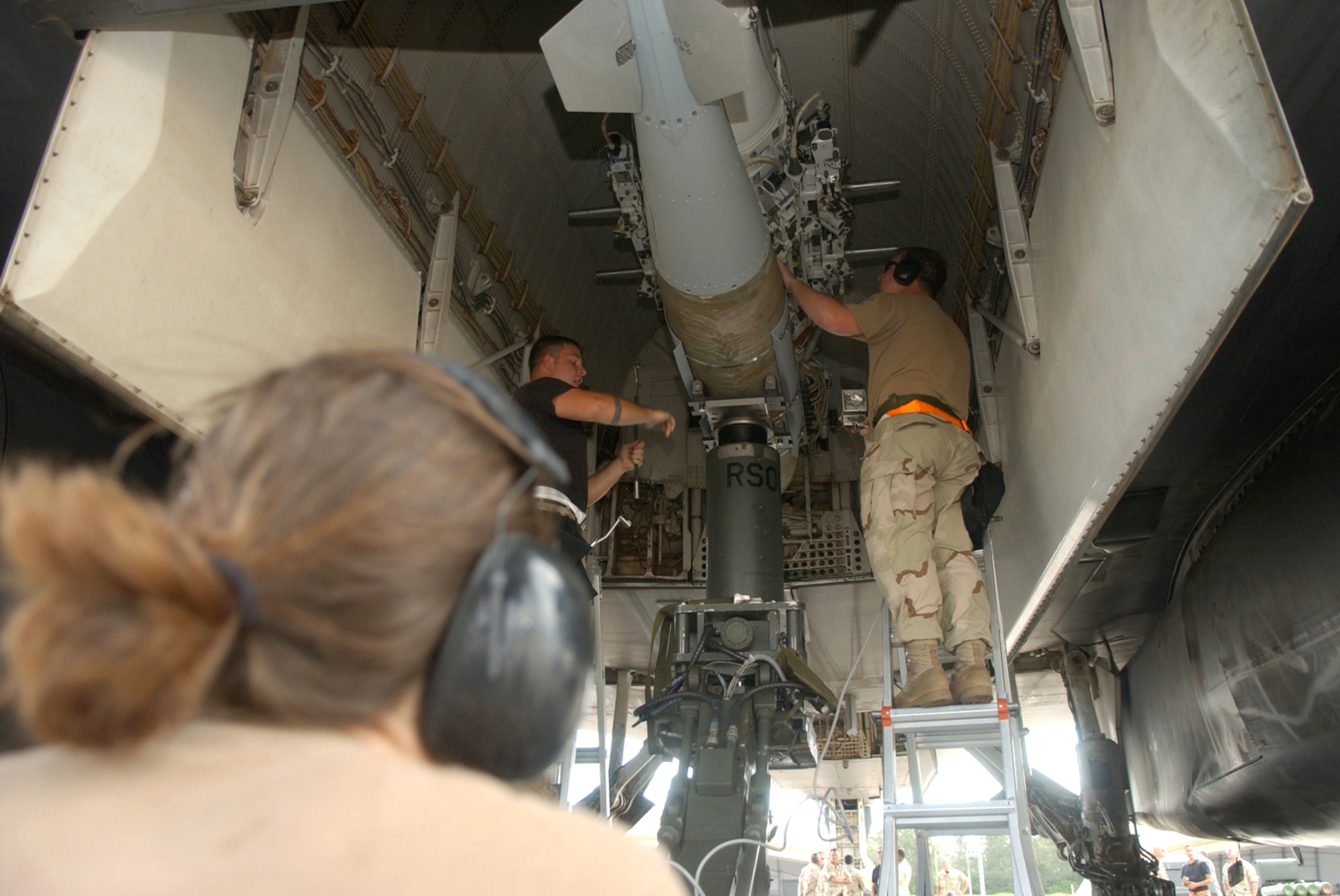 Staff Sgt. Anthony Bray (left) and Staff Sgt. Christopher Strange (right) lock a 2,000-pound Joint Direct Attack Munition into a B-1B Lancer bomb bay. The Airmen are deployed to the 40th Expeditionary Maintenance Squadron from Dyess Air Force Base, Texas. (U.S. Air Force photo/Staff Sgt. Patrick Mitchell) 