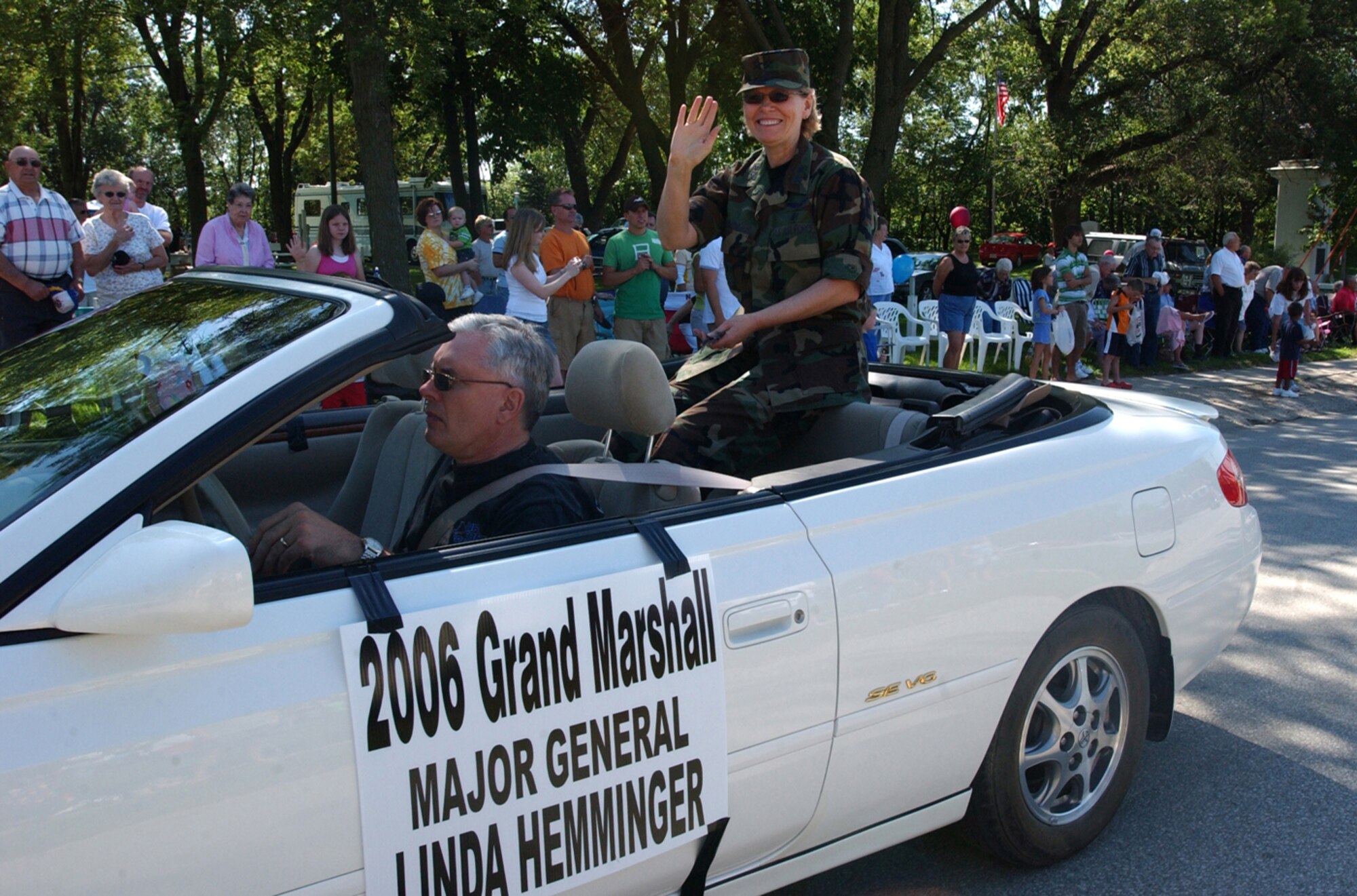 ADAIR, Iowa -- Maj. Gen. Linda S. Hemminger, grand marshall of the Annual Jesse James Parade, waves to her neighbors in Adair, Iowa, July 22, 2006. General Hemminger handed out pens and pencils as she represented her job in the Air Force Reserve as a mobilization assistant to the Assistant Surgeon General for Nursing Services and the Assistant Surgeon General for Health Care Operations. She went through the parade a second time, handing out candy as a registered nurse with the Cass County Memorial Hospital, Home Care/Hospice, Atlantic, Iowa.  She spends about half of her time working at the Pentagon and half of her time working for the hospice. "I have lived in this community for 25 years," the general said. "Being a Citizen Airman is a huge support for the military. We can't be full time but we bring so much from our civilian jobs and represent the communities we live in." (U.S. Air Force photo/2nd Lt Jolene Bottor) 